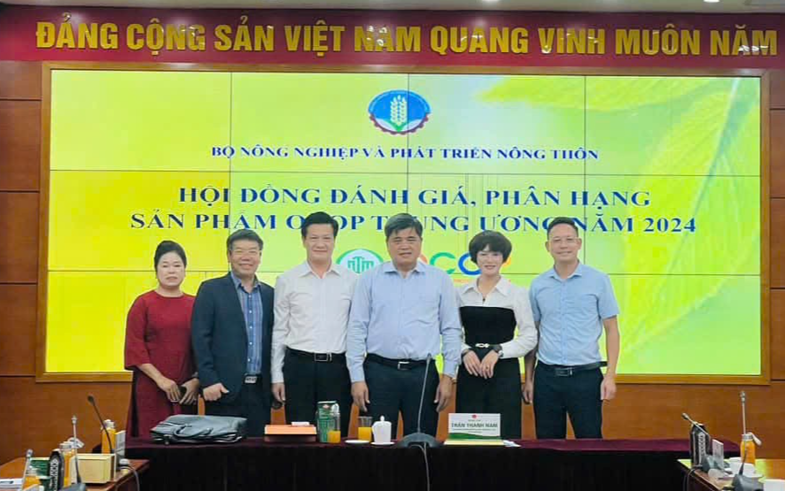 Chị Nguyễn Thị Lê, Giám đốc Công ty Cổ phần Công nghệ dược liệu Bắc Hà (áo dài đỏ) chụp ảnh lưu niệm với Hội đồng đánh giá phân hạng sản phẩm OCOP Trung ương năm 2024.