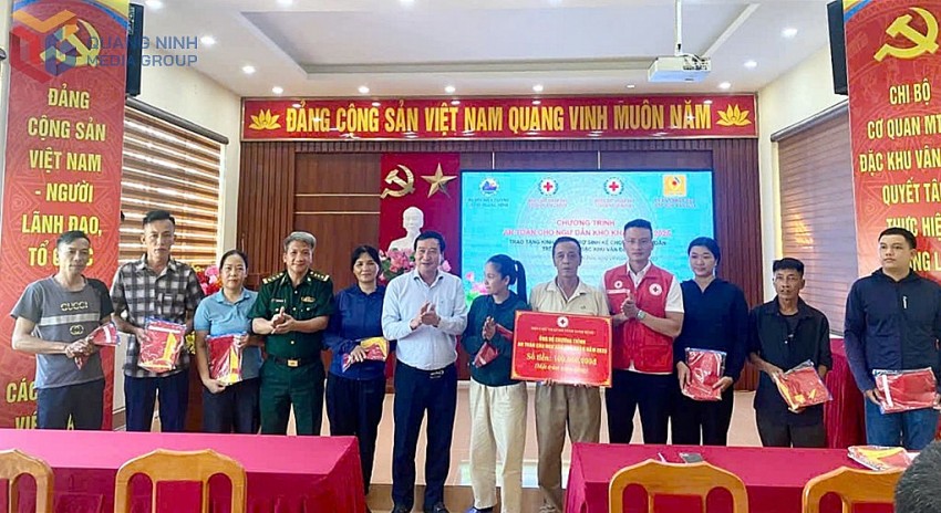 Lãnh đạo Hội Chữ Thập đỏ tỉnh, Ban Chỉ huy Bộ đội Biên phòng tỉnh, đặc khu Vân Đồn trao kinh phí hỗ trợ và cờ Tổ quốc cho ngư dân khó khăn trên địa bàn . Ảnh:QMG