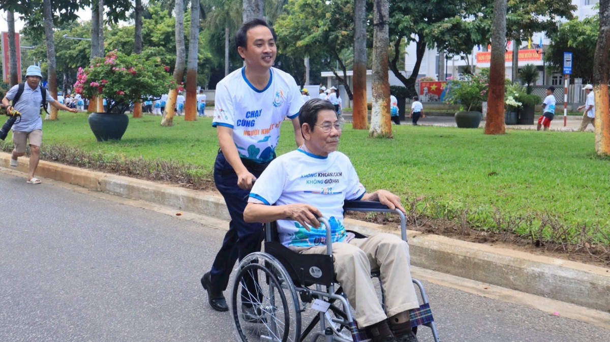 Người tham gia hỗ trợ di chuyển cho người cao tuổi trong hoạt động cộng đồng, lan tỏa tinh thần sẻ chia và đồng hành.