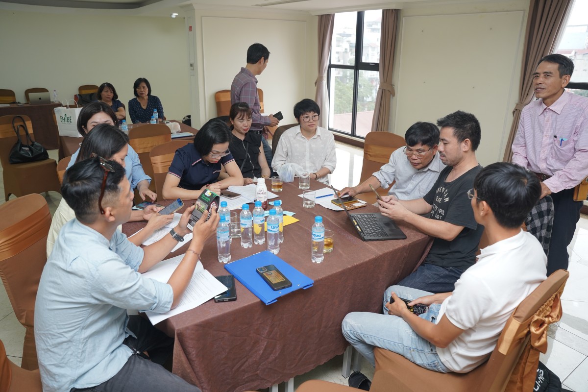 Các học viên quan sát tem truy xuất nguồn gốc, logo chứng nhận và thông tin bao bì tại cửa hàng bán sản phẩm hữu cơ.