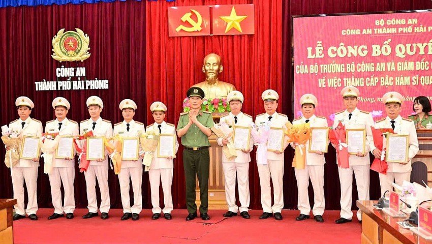 Đại tá Phạm Viết Dũng - Phó  Giams đốc Công an TP. Hải Phòng trao quyết định và tặng hoa chúc mừng các Trưởng Công an cấp xã được thăng cấp bậc Thượng tá. 