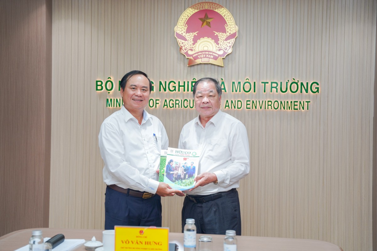 TSKH. Hà Phúc Mịch, Chủ tịch Hiệp hội Nông nghiệp hữu cơ Việt Nam, trao tặng ấn phẩm Tạp chí Hữu cơ Việt Nam tới Thứ trưởng Bộ Nông nghiệp và Môi trường Võ Văn Hưng tại buổi làm việc.