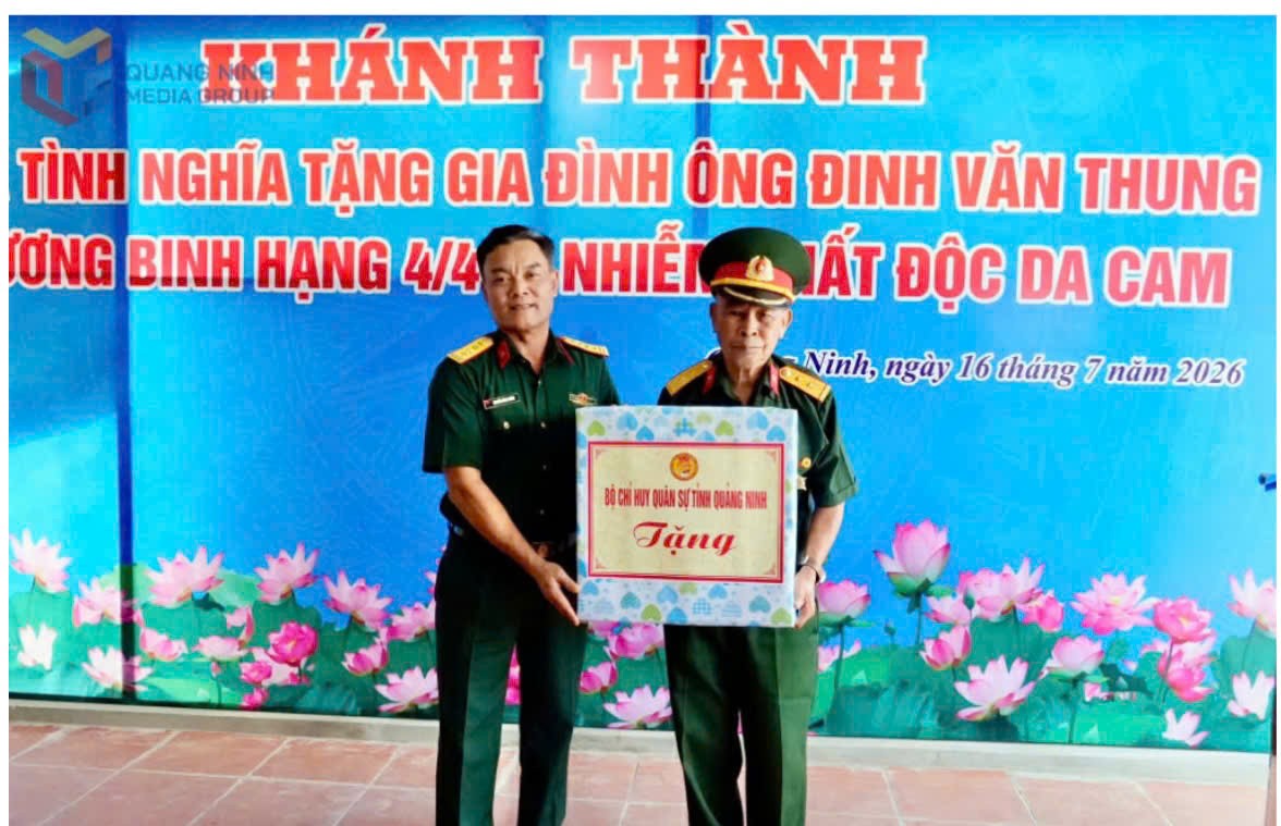Đại tá Nguyễn Đình Khiêm, Phó Chính uỷ Bộ CHQS tỉnh, trao tặng quà của Bộ CHQS tỉnh cho ông Thung. Ảnh: QMG