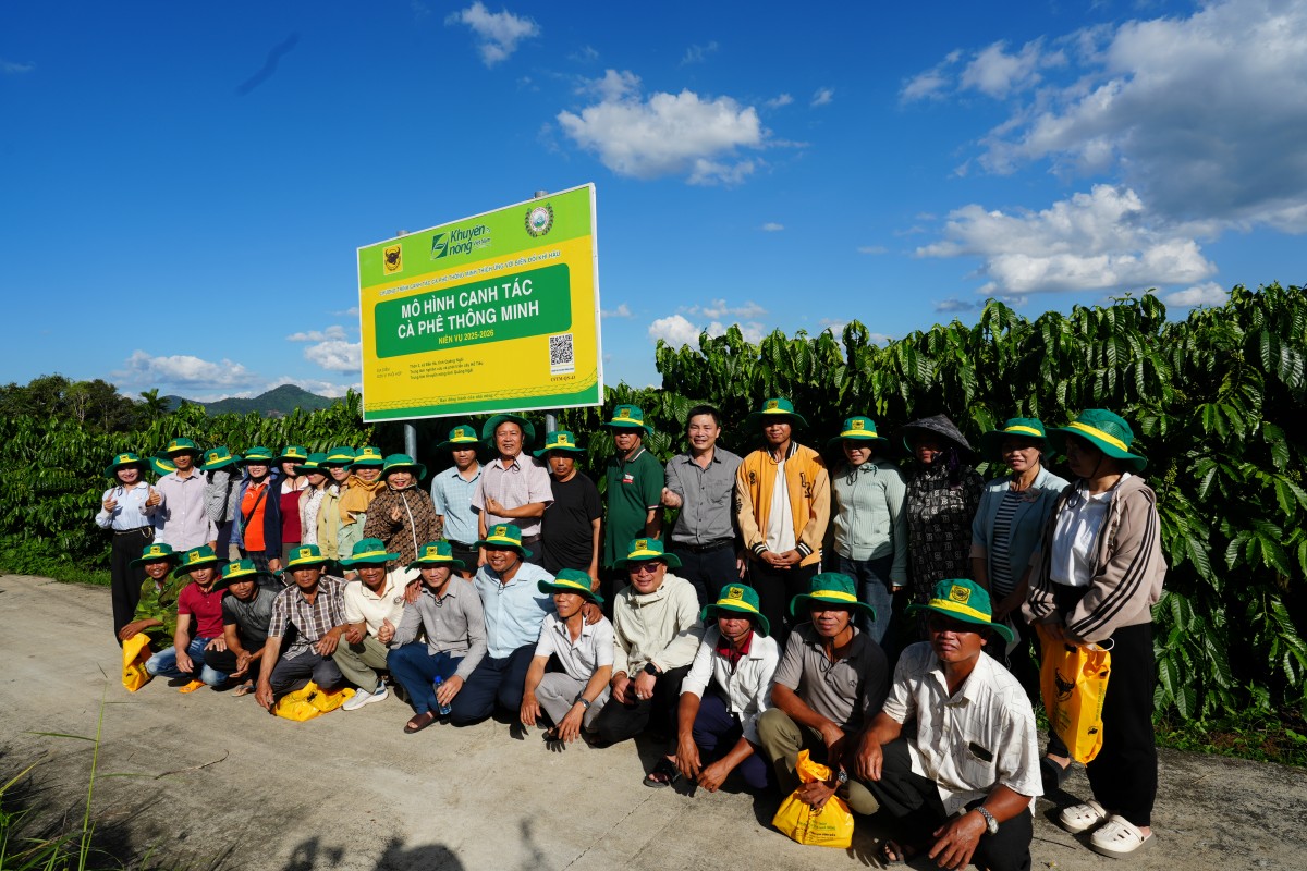 Đại biểu, nhà khoa học và nông dân chụp ảnh lưu niệm trước bảng mô hình Canh tác cà phê thông minh tại Đắk Hà.