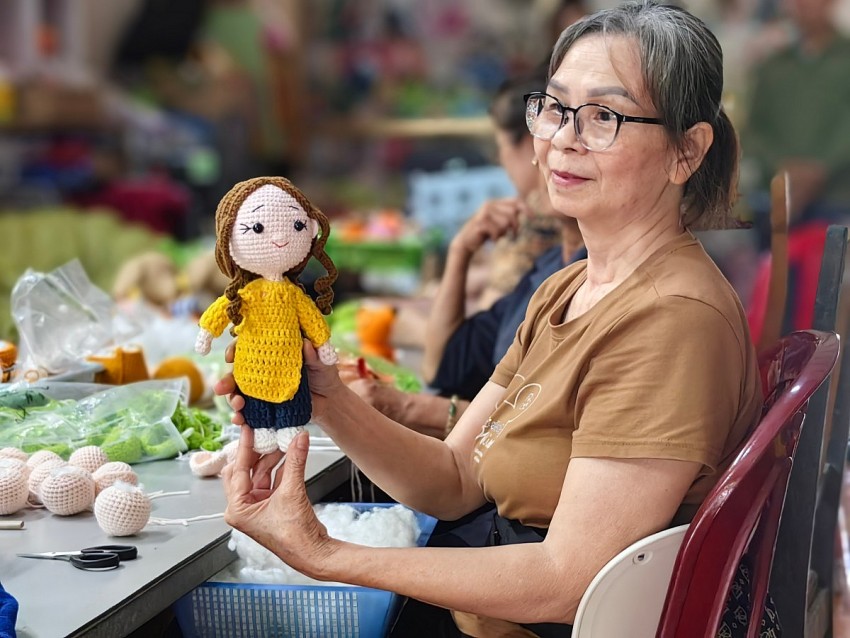 Hoàng Thị Hà, 67 tuổi và ản phẩm được tạo ra từ đôi bàn tay của những người phụ nữ lớn tuổi. Ảnh: Duy Tùng