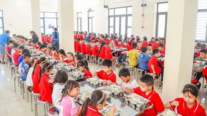 Học sinh ngồi ăn ngắn trong bữa ăn tại nhà ăn bán trú của trường. 